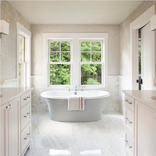 Windows in a bathroom with a stunning white bathtub