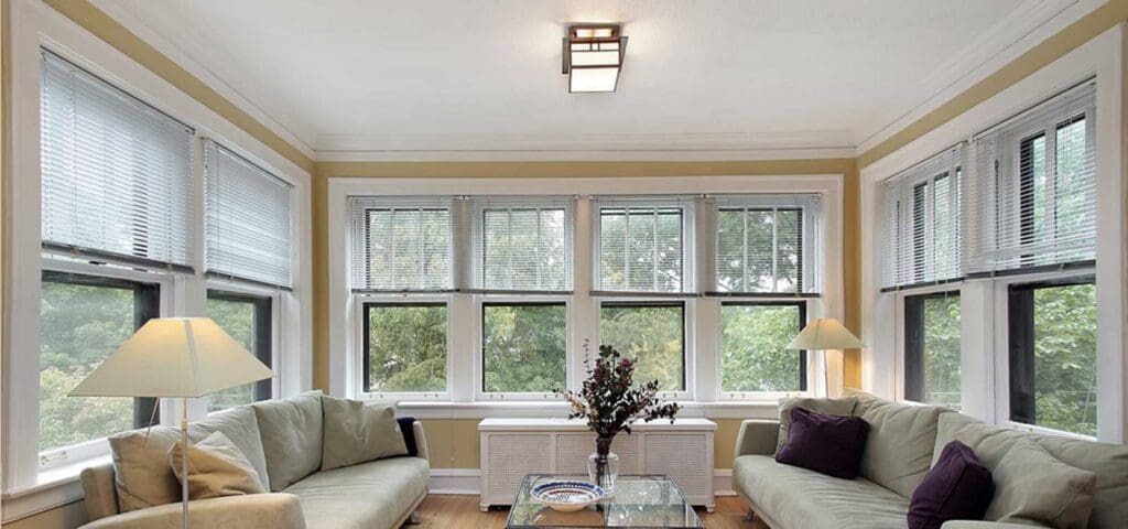 Sunny and vibrant living room designed by HXHome Solutions, bathed in natural light from expansive windows, creating a cheerful and inviting space.